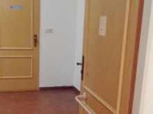 Podlaha chodby vedoucí k toaletě, dveře s madlem